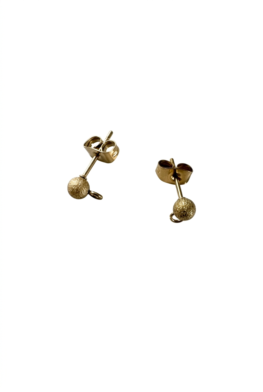 Clous d’oreilles boules dorés sur fond blanc