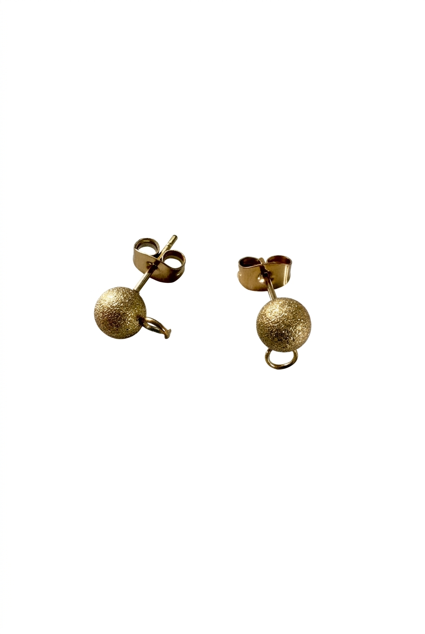 Clous d’oreilles boules dorés sur fond blanc