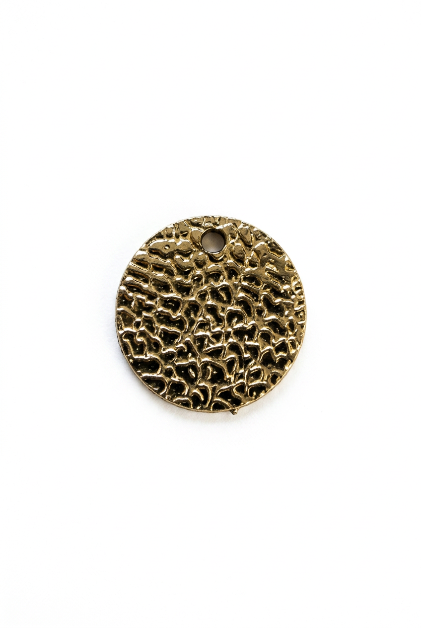 Sequin rond doré texturé sur fond blanc